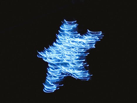 Blurry abstract star shape created with blue lights on a dark background.