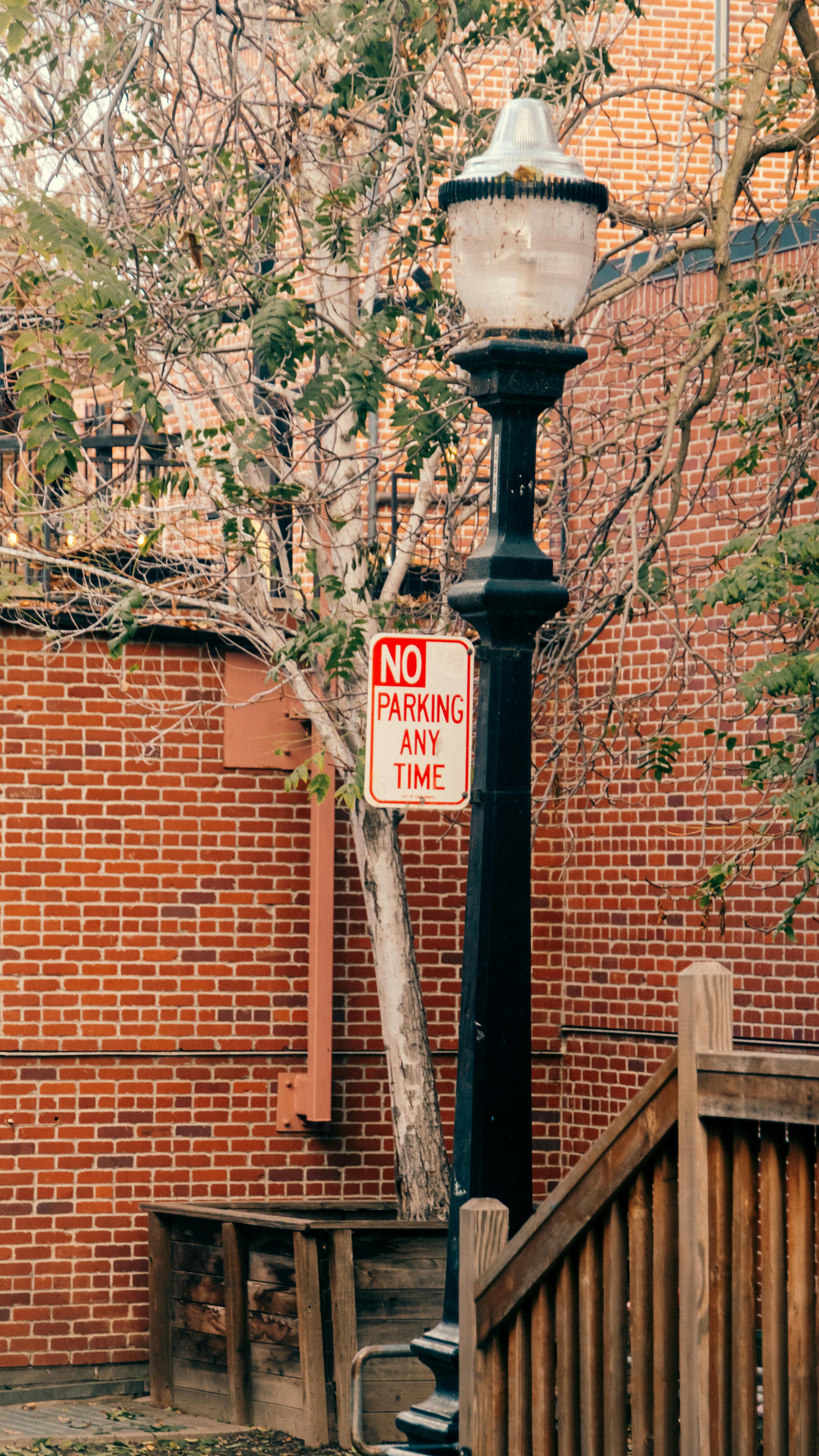Gratuit O scenă stradală urbană elegantă, cu un stâlp de iluminat vintage și un indicator de interzicere a parcării pe pereții de cărămidă. Fotografie de stoc