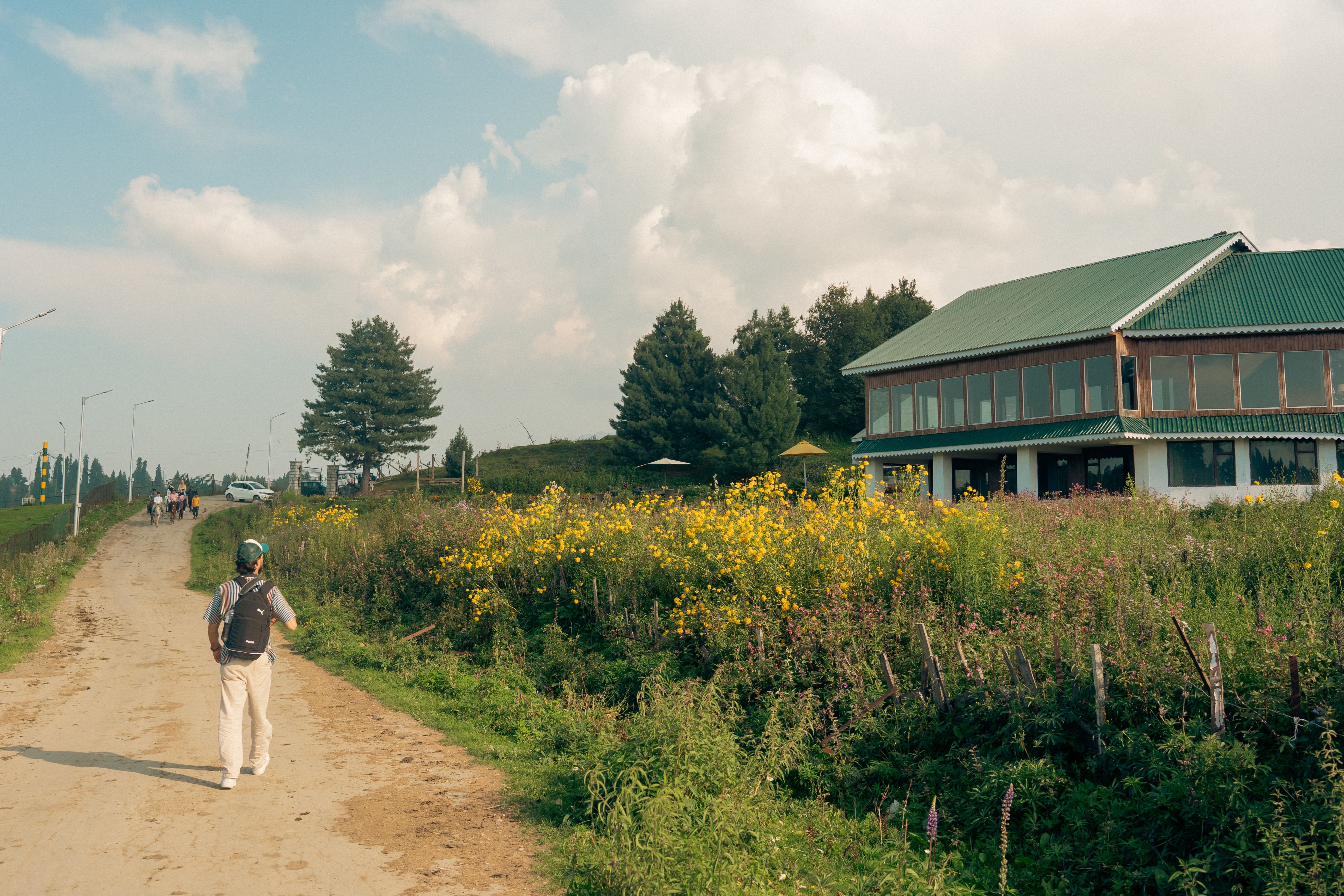 Scenic Rural Pathway with Rustic House and Hiker · Free Stock Photo