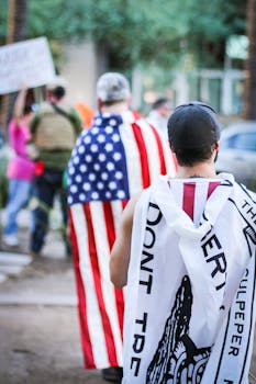 白天，抗议者在户外集会上身披旗帜