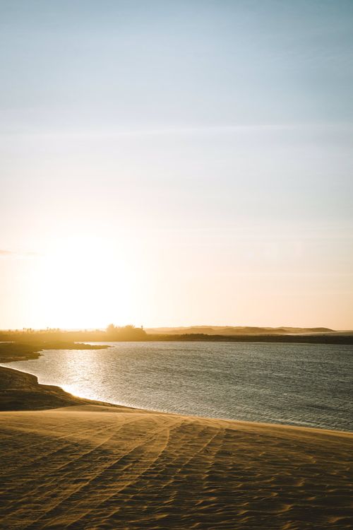 Free Peaceful sunset over a serene ocean and sandy beach, ideal for relaxation and tranquility. Stock Photo