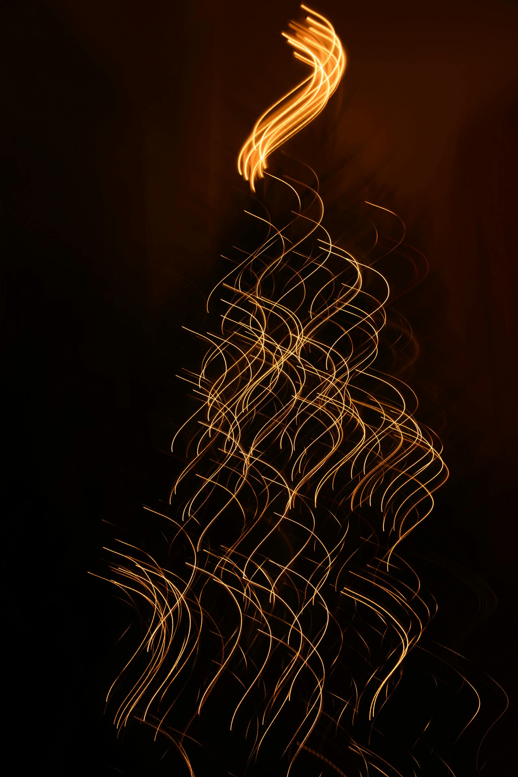 Gratis Estelas de luz abstractas que forman la figura de un árbol de Navidad sobre un fondo oscuro. Foto de stock