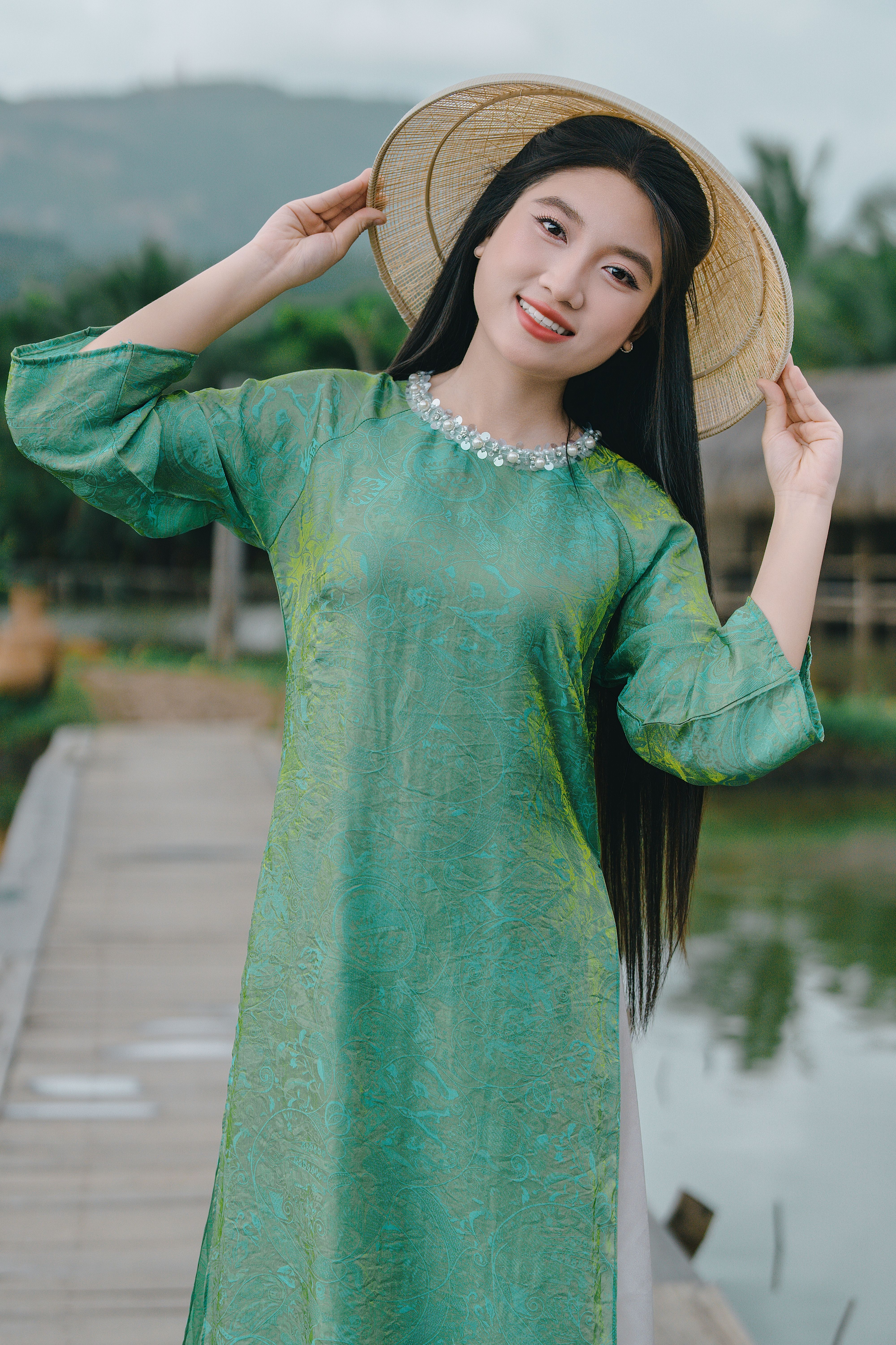 Woman in Traditional Dress Holding Bamboo Hat Outdoors  Free Stock Photo