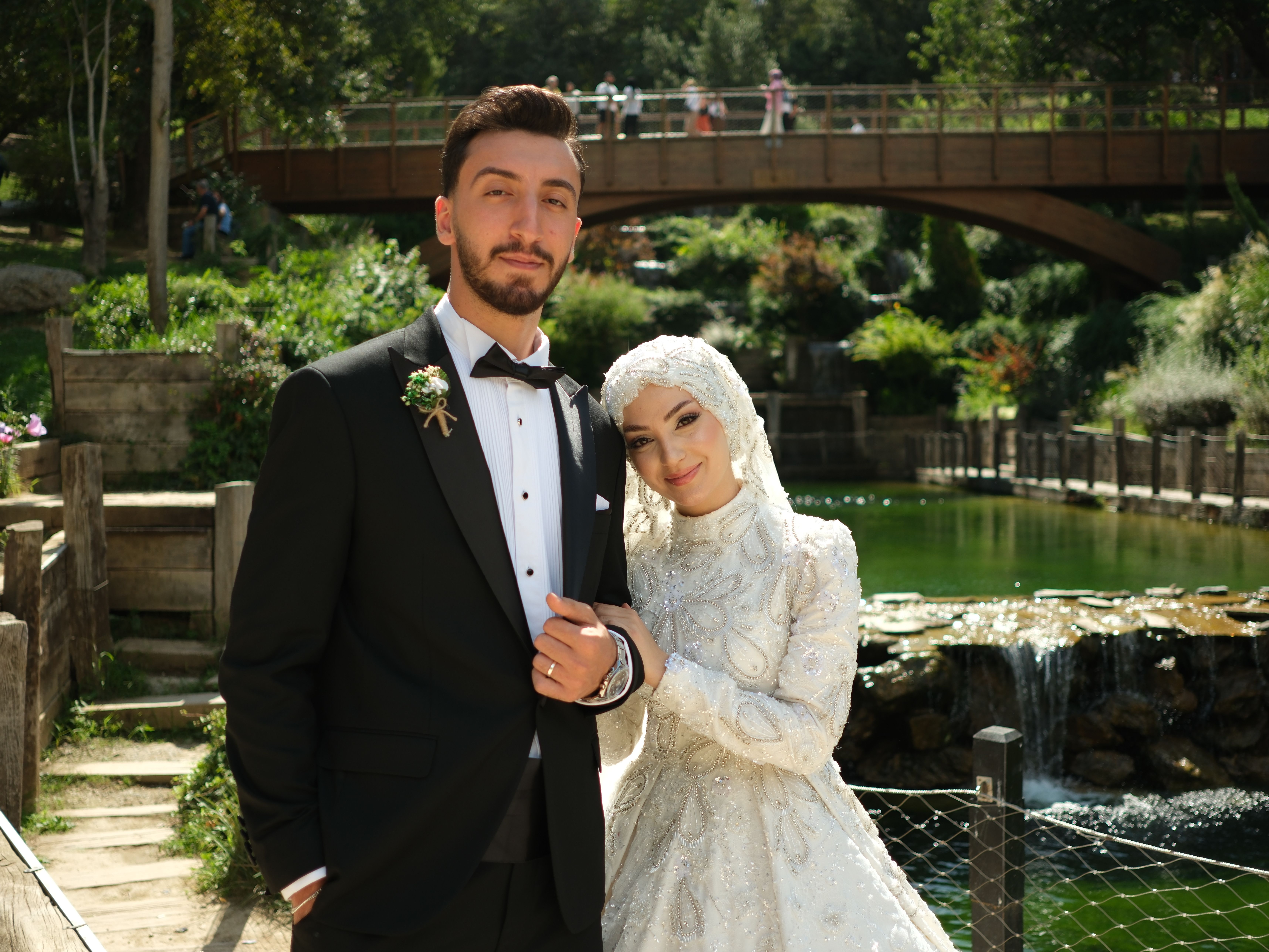 Elegant outdoor wedding portrait by a serene pond