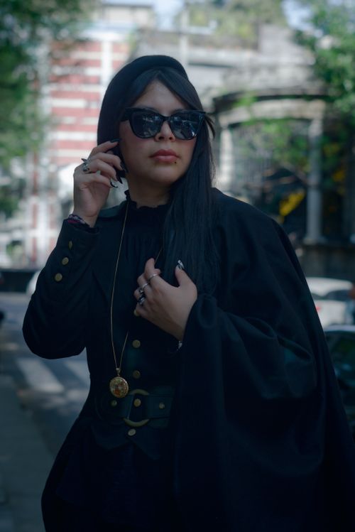 Free Stylish woman in black with sunglasses and cape, walking confidently in Ciudad de México. Stock Photo