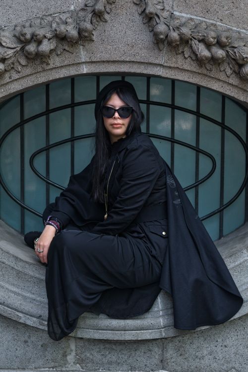 Free Stylish woman in black posed on stone architecture in Mexico City. Stock Photo