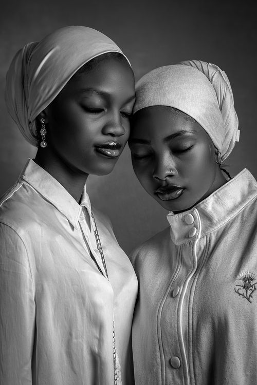 Free A graceful black and white portrait capturing the serene essence of two women in headscarves. Stock Photo