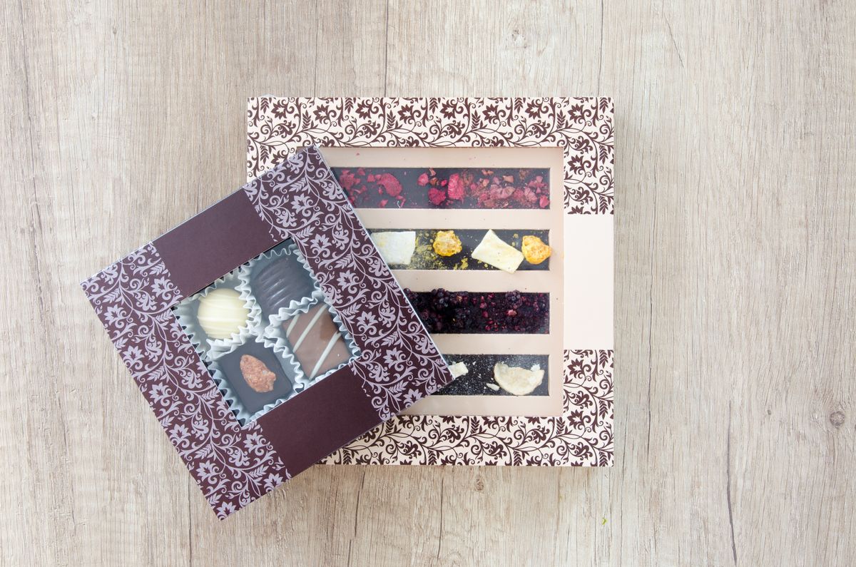 Delicious assortment of chocolates and sweets in beautifully designed boxes on a wooden tabletop.