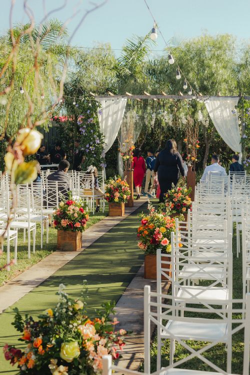 Free Beautiful outdoor wedding setup with chairs and floral arrangements. Perfect garden ambiance for celebrations. Stock Photo