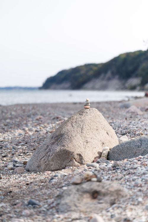 Free Serene coastal scene showcasing balanced stones on a rocky beach, perfect for mindfulness and relaxation themes. Stock Photo