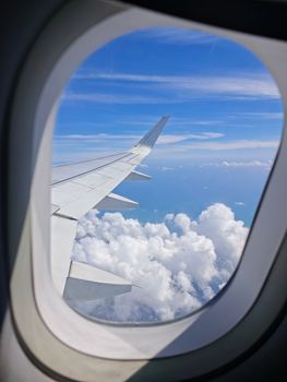 A stunning view of clouds and sky through an airplane window during flight.