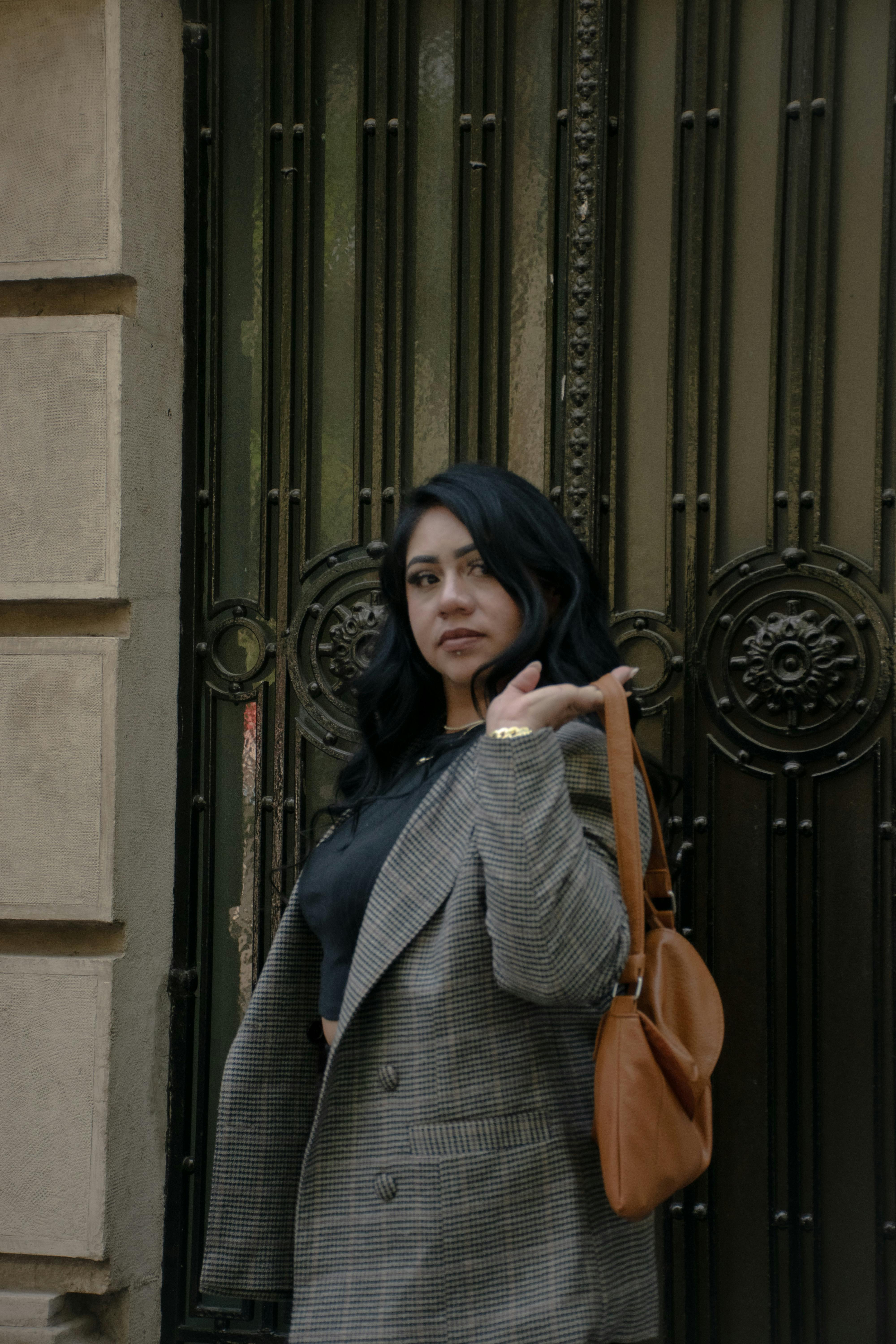 Miễn phí Người phụ nữ tự tin trong trang phục sành điệu tạo dáng bên cổng trang trí cầu kỳ, toát lên vẻ thanh lịch. Ảnh lưu trữ