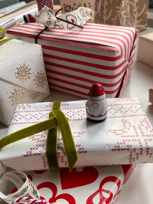 Free Colorful Christmas presents wrapped with care, featuring a tiny Santa figurine. Stock Photo