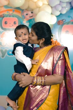 A joyful moment captured at a baby boy's first birthday party with a loving embrace.