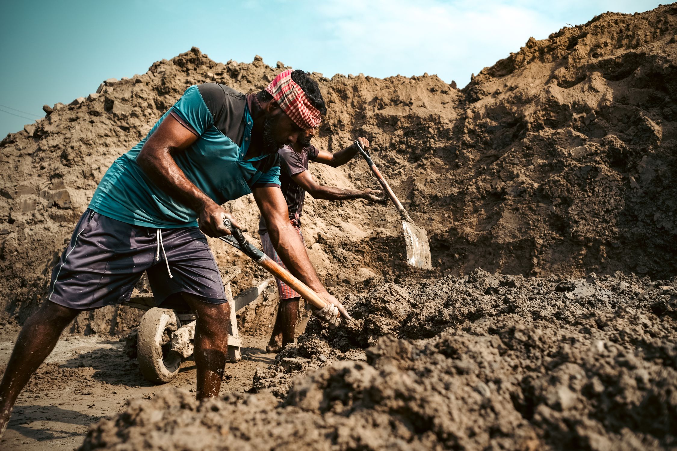 Digging By Compress Manual Laborers Digging in a Muddy Site · Free Stock Photo