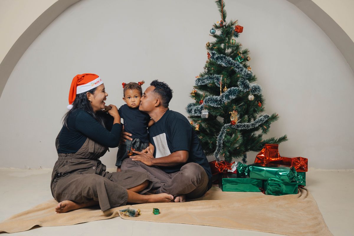 Family celebrating Christmas together with tree and gifts