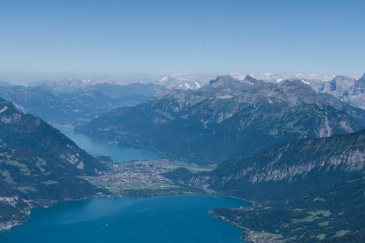 Stunning aerial view of Lake Thun surrounded by the majestic Swiss Alps under a clear blue sky.