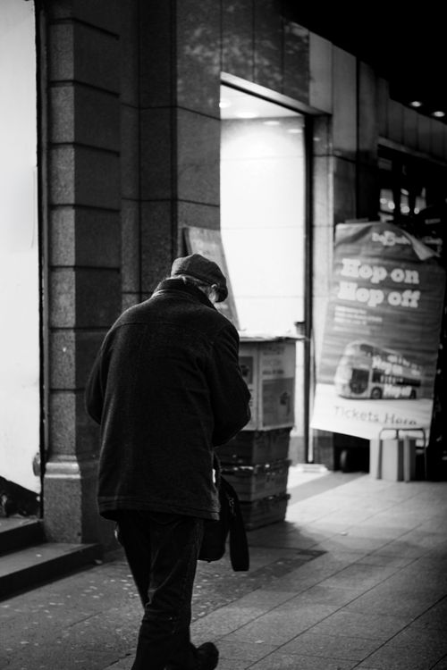 Free Black and white image of an elderly man walking in Dublin, capturing solitude. Stock Photo