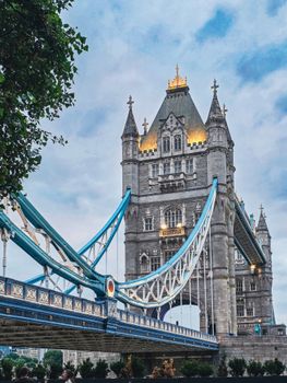 Stunning view of the illuminated Tower Bridge in London against a cloudy sky, showcasing classic architecture.