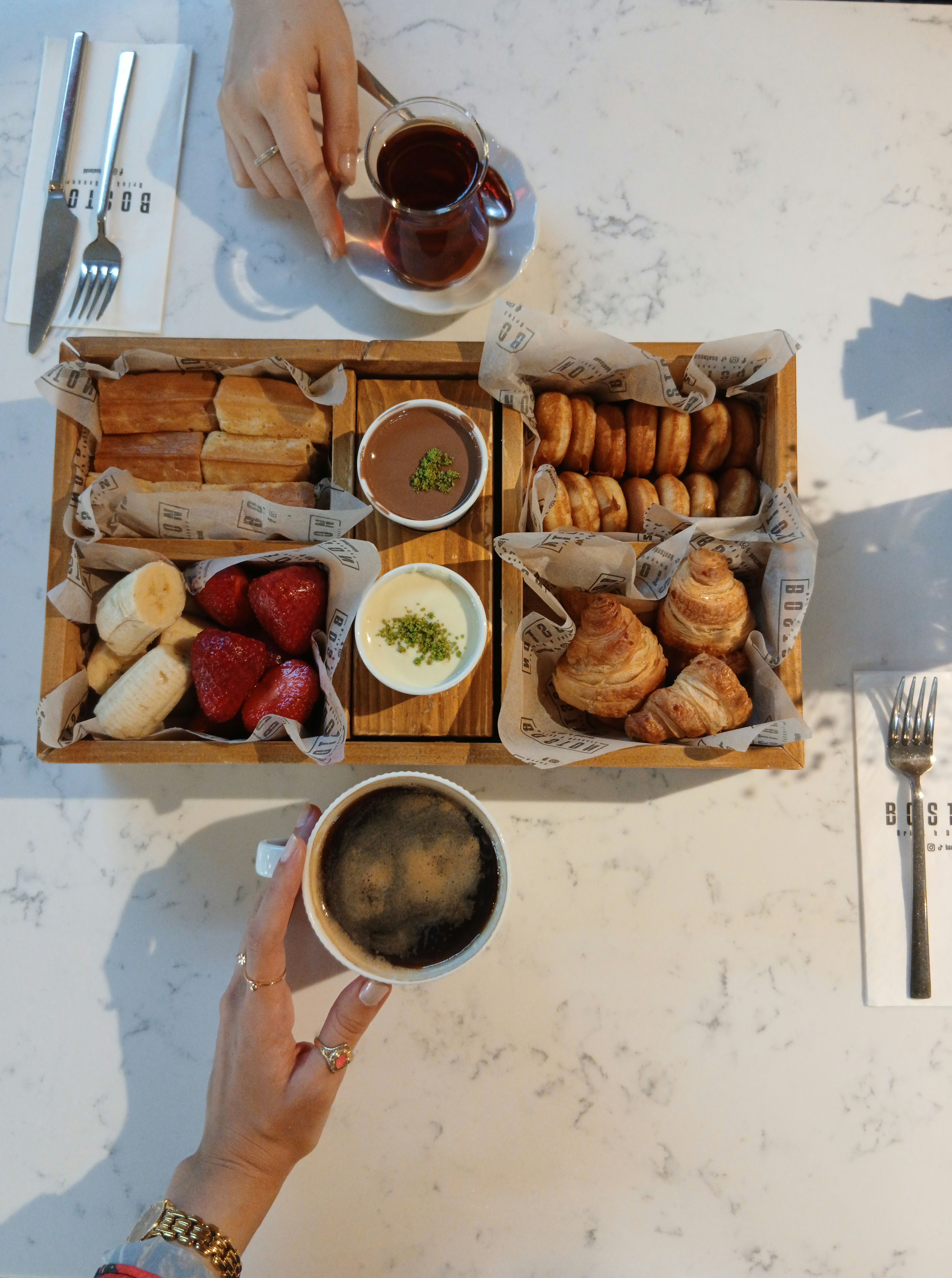 Overhead view of a delicious breakfast tray featuring pastries, fruits, and coffee.