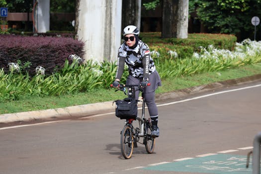 Woman cycling in a Jakarta park in sportswear and helmet, showcasing urban outdoor activity.