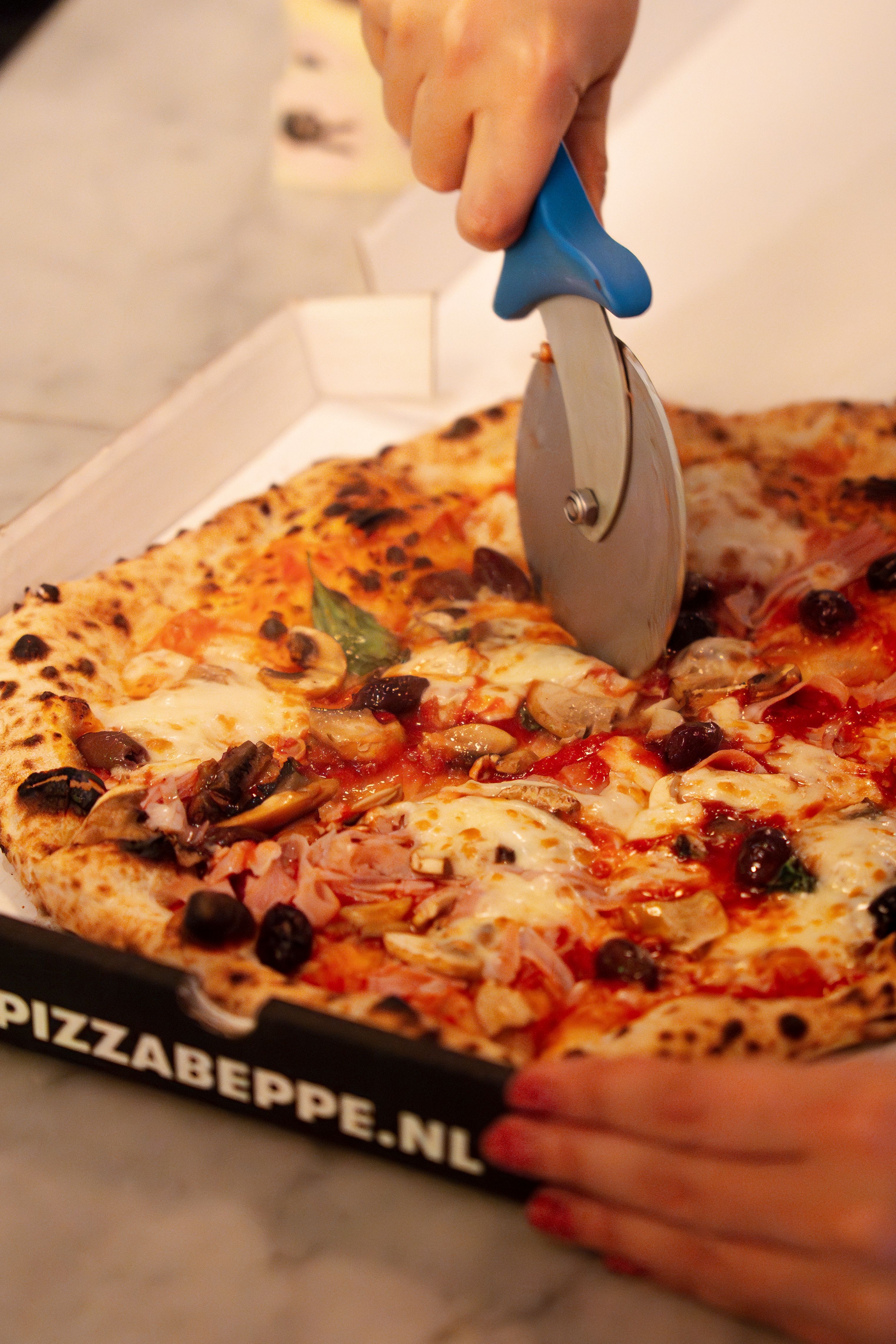 Close-up of a fresh Neapolitan pizza being sliced. Perfect for food and lifestyle themes.
