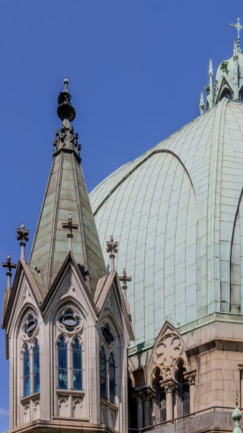 Free Close-up of a Gothic cathedral dome with ornate details under a clear blue sky. Stock Photo