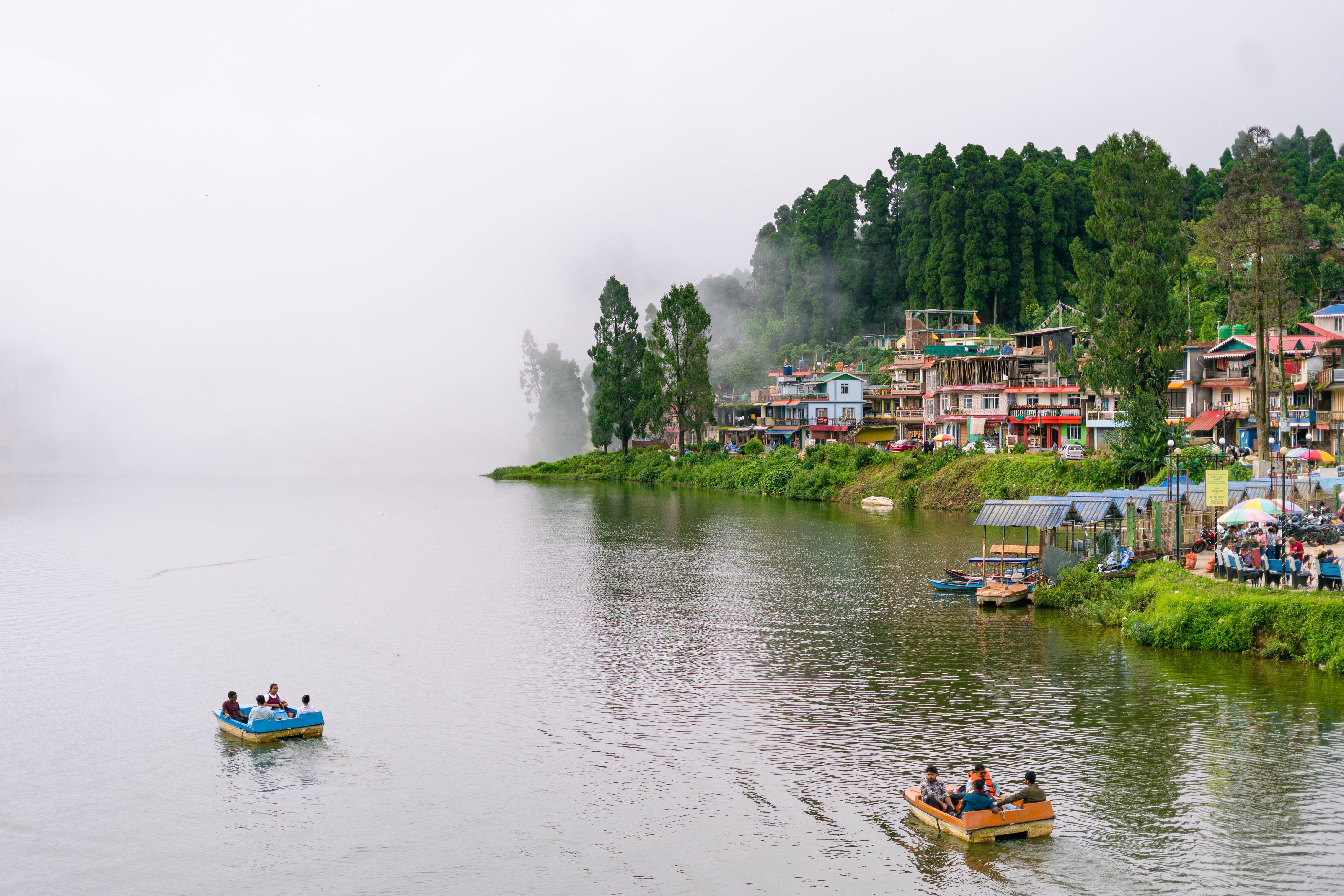 Mist over a lake below a hillside resort terrace in the Sahyadri hills
