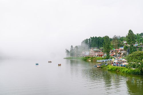 Free Experience the misty beauty of Mirik Lake, West Bengal, India, surrounded by lush greenery. Stock Photo