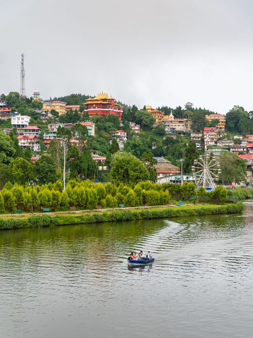 Free Enjoy a serene boating experience on Mirik Lake, nestled amidst lush hills and colorful architecture in West Bengal, India. Stock Photo