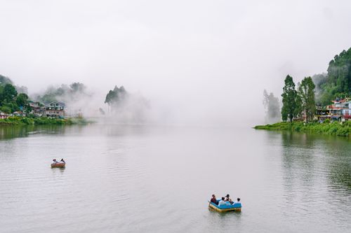 Free Peaceful scene of boaters on a foggy Mirik Lake in West Bengal, India. Stock Photo