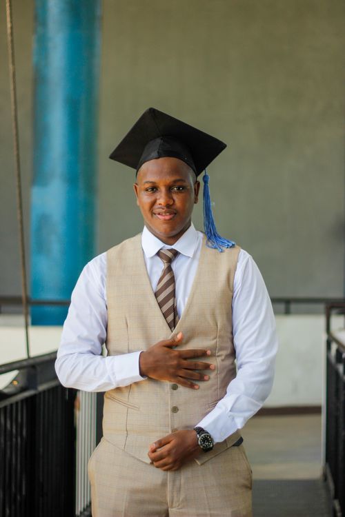 Free Young man in graduation cap and tie, celebrating achievement indoors. Stock Photo