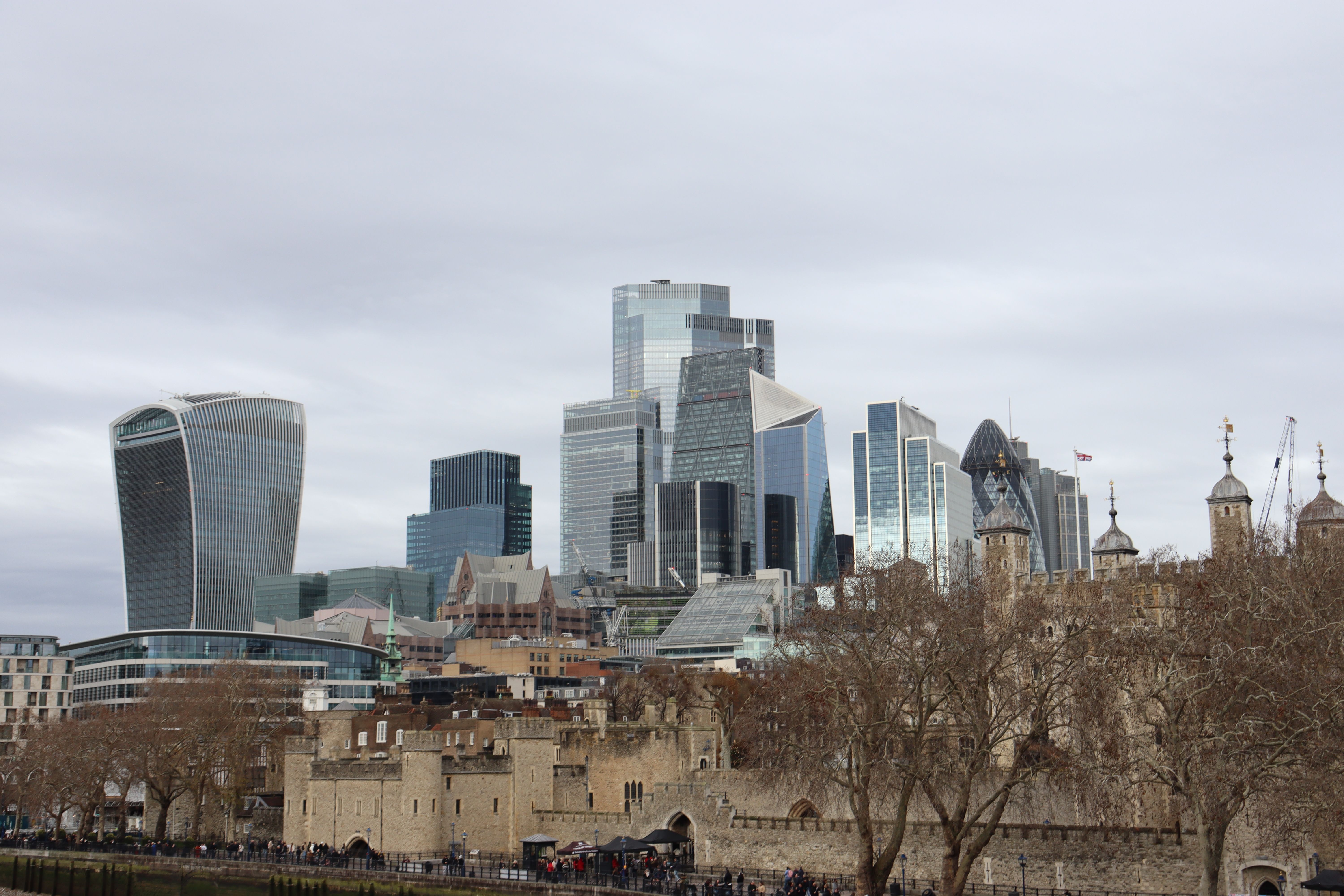 The iconic skyline of London featuring modern skyscrapers and the historic Tower of London.