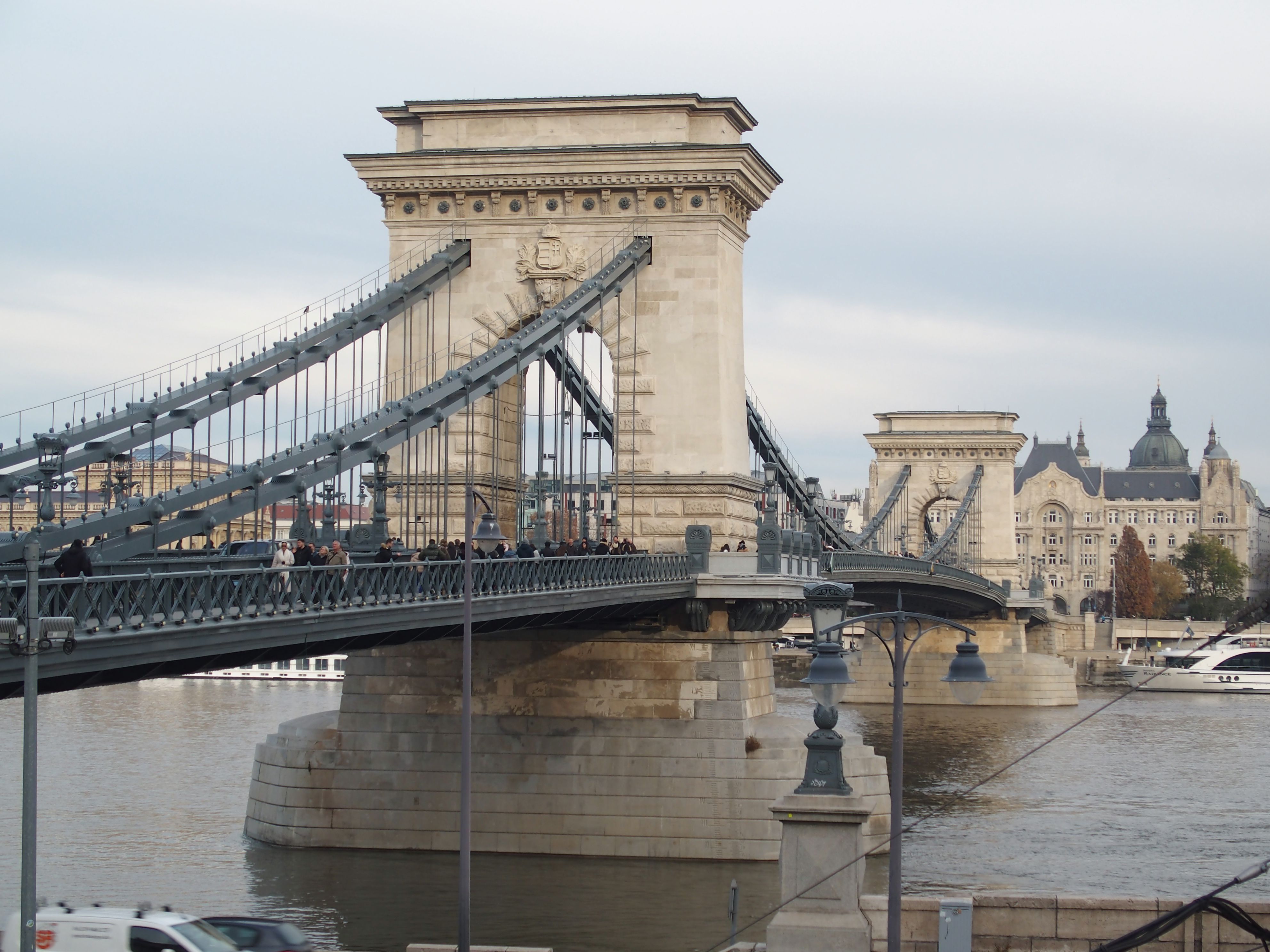 Chain Bridge at golden hour with Danube River views, Gothic spires, and historic courtyards glowing in warm evening light