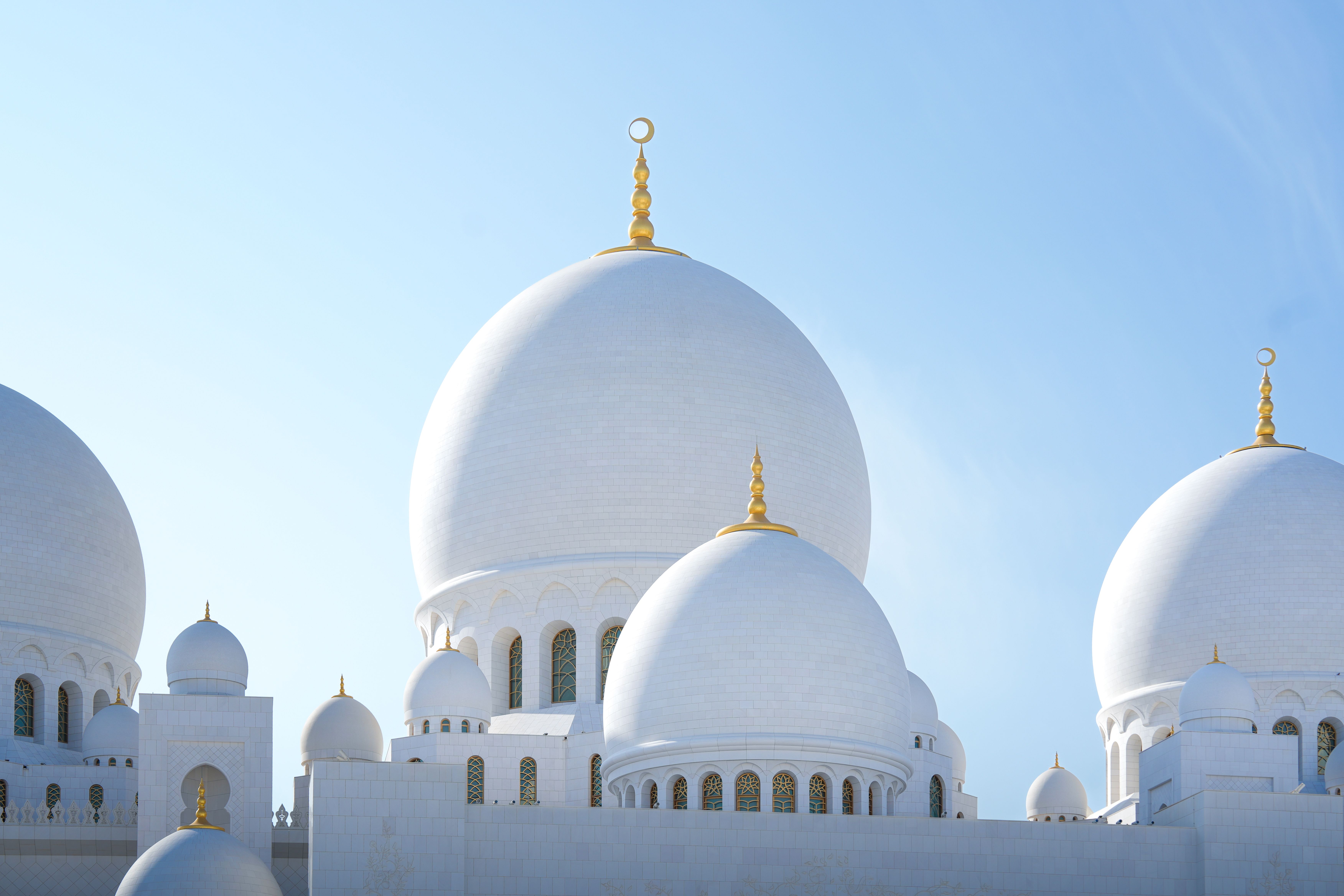 Captivating view of Sheikh Zayed Grand Mosque domes in Abu Dhabi, UAE, under a clear blue sky.