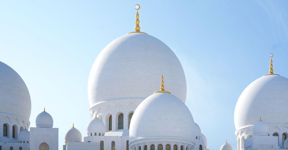 Captivating view of Sheikh Zayed Grand Mosque domes in Abu Dhabi, UAE, under a clear blue sky.