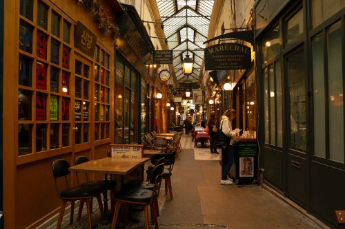Free Cozy indoor shopping passage lined with vibrant shops and cafes in Paris, France. Stock Photo