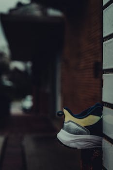 Close-up of a sneaker on a gloomy urban street corner, evoking a moody atmosphere.