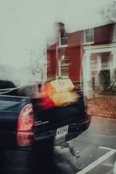 Abstract motion blur of a pickup truck on a rainy street in Georgia, capturing a moody atmosphere.