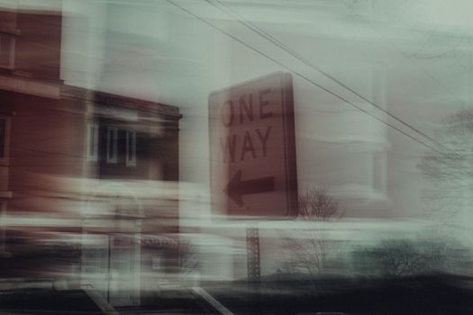 Abstract cityscape with a blurred one-way sign capturing urban motion.