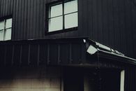 Dramatic shot of a building's exterior under rainy conditions, highlighting dark tones.