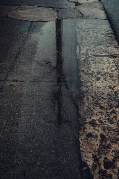 Atmospheric urban scene with puddle reflections on a rainy day in downtown Georgia.