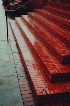 Moody image of rain-soaked red brick steps, capturing urban atmosphere.