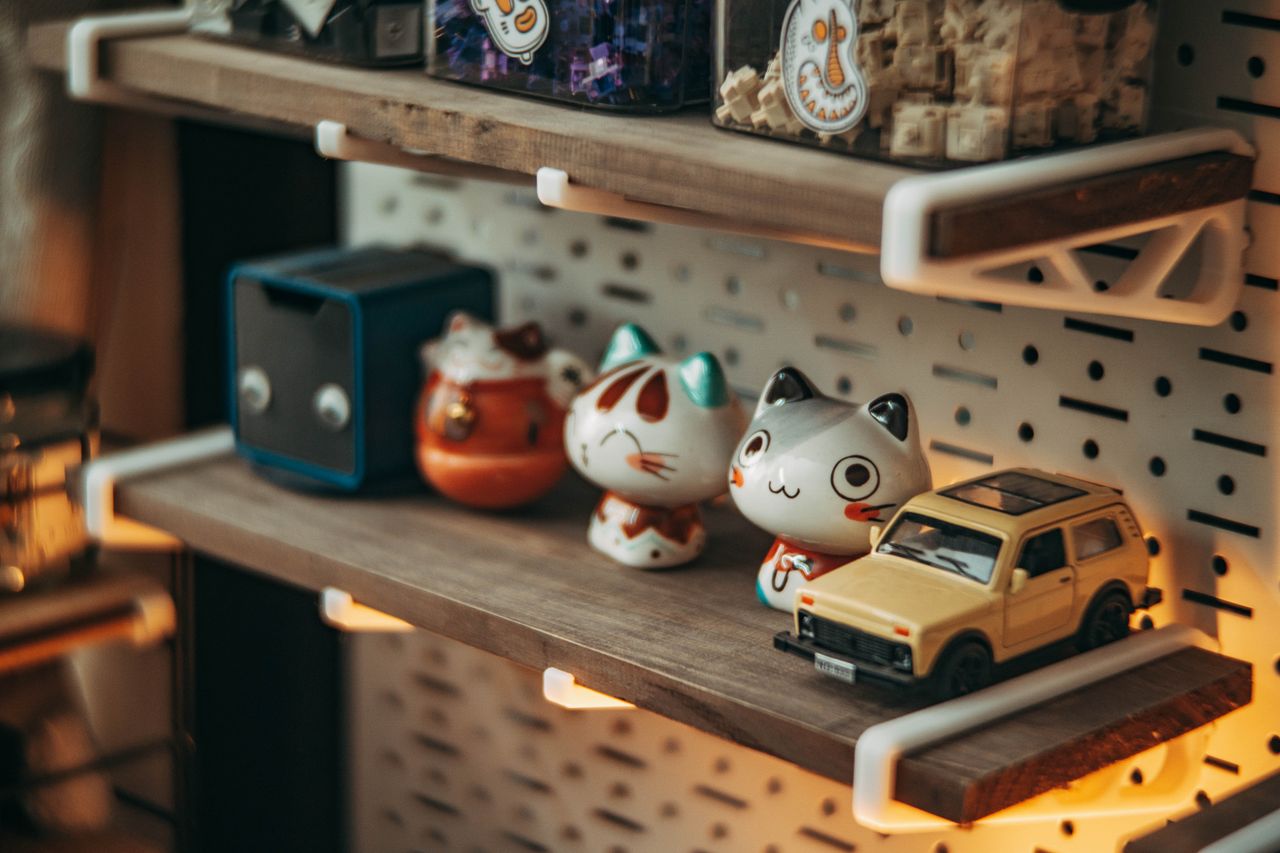 wooden shelf with cute cat figurines and toy car soft ambient lighting