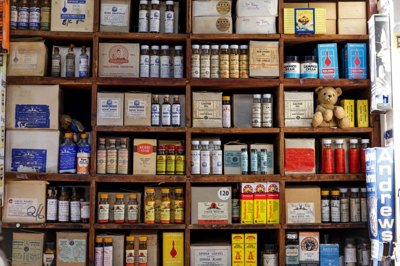A vintage pharmacy shelf filled with old medicine bottles and boxes, showcasing a nostalgic aesthetic.