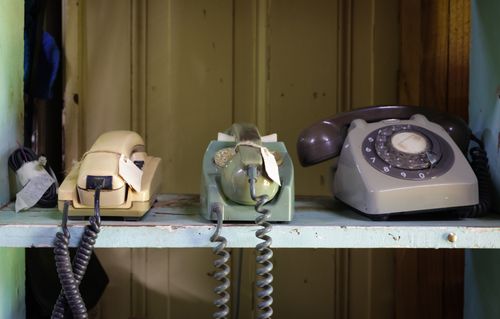 Free Collection of vintage rotary and push-button telephones on a shelf. Stock Photo