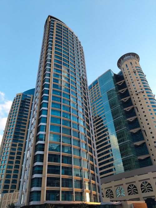 Free A cluster of modern high-rise buildings under a clear blue sky, showcasing urban architecture. Stock Photo