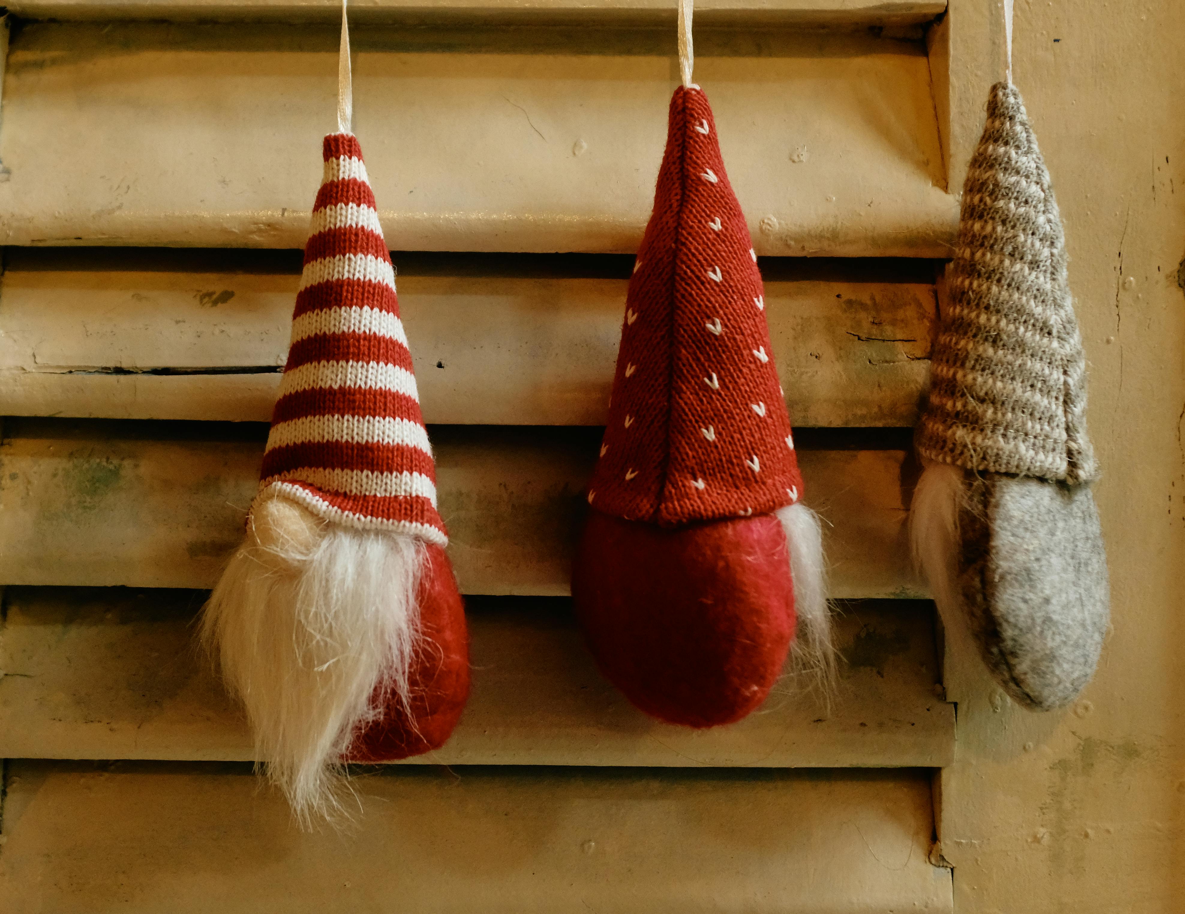 grátis Enfeites de gnomos encantadores enfeitam uma veneziana rústica de madeira, adicionando um toque festivo. Foto profissional