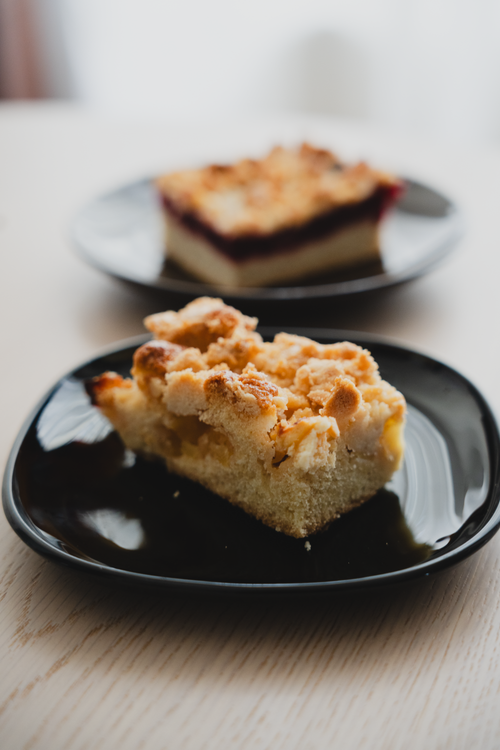 Free Close-up of a streuselkuchen slice on a black plate, perfect for dessert lovers. Stock Photo