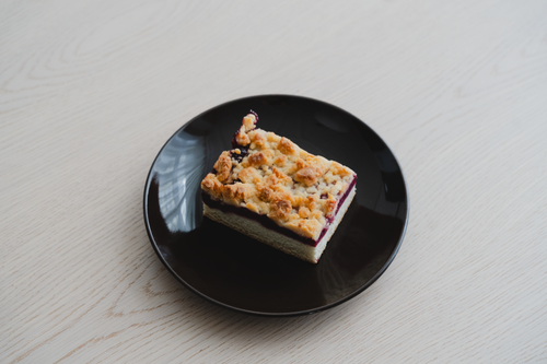 Free A tempting slice of streuselkuchen with berry filling on a black plate, perfect for dessert lovers. Stock Photo